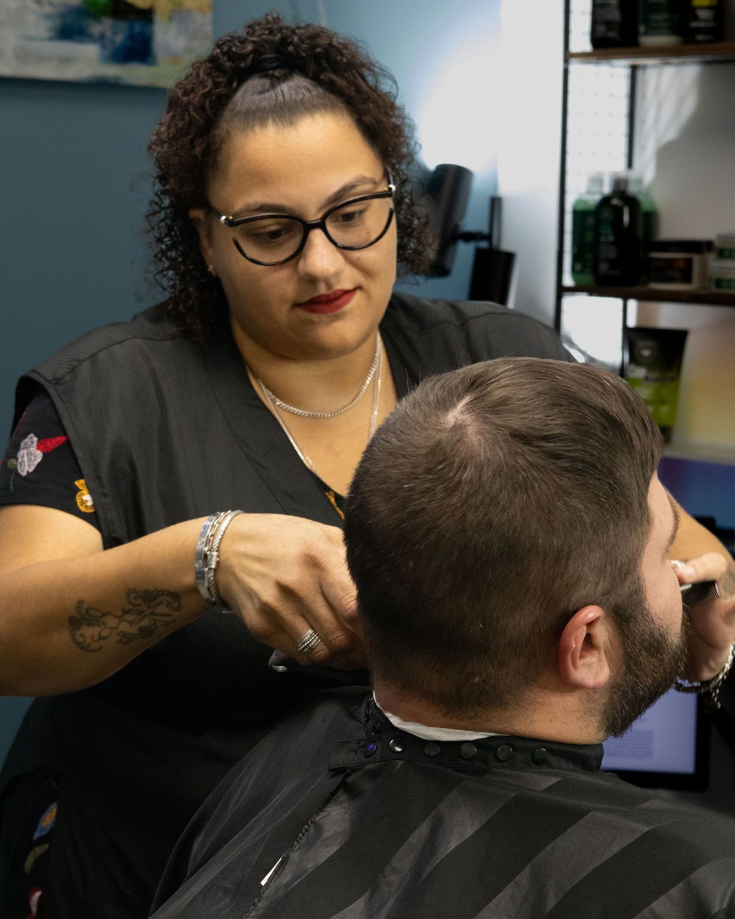 A professional stylist cuts a client's hair in a modern salon setting.
