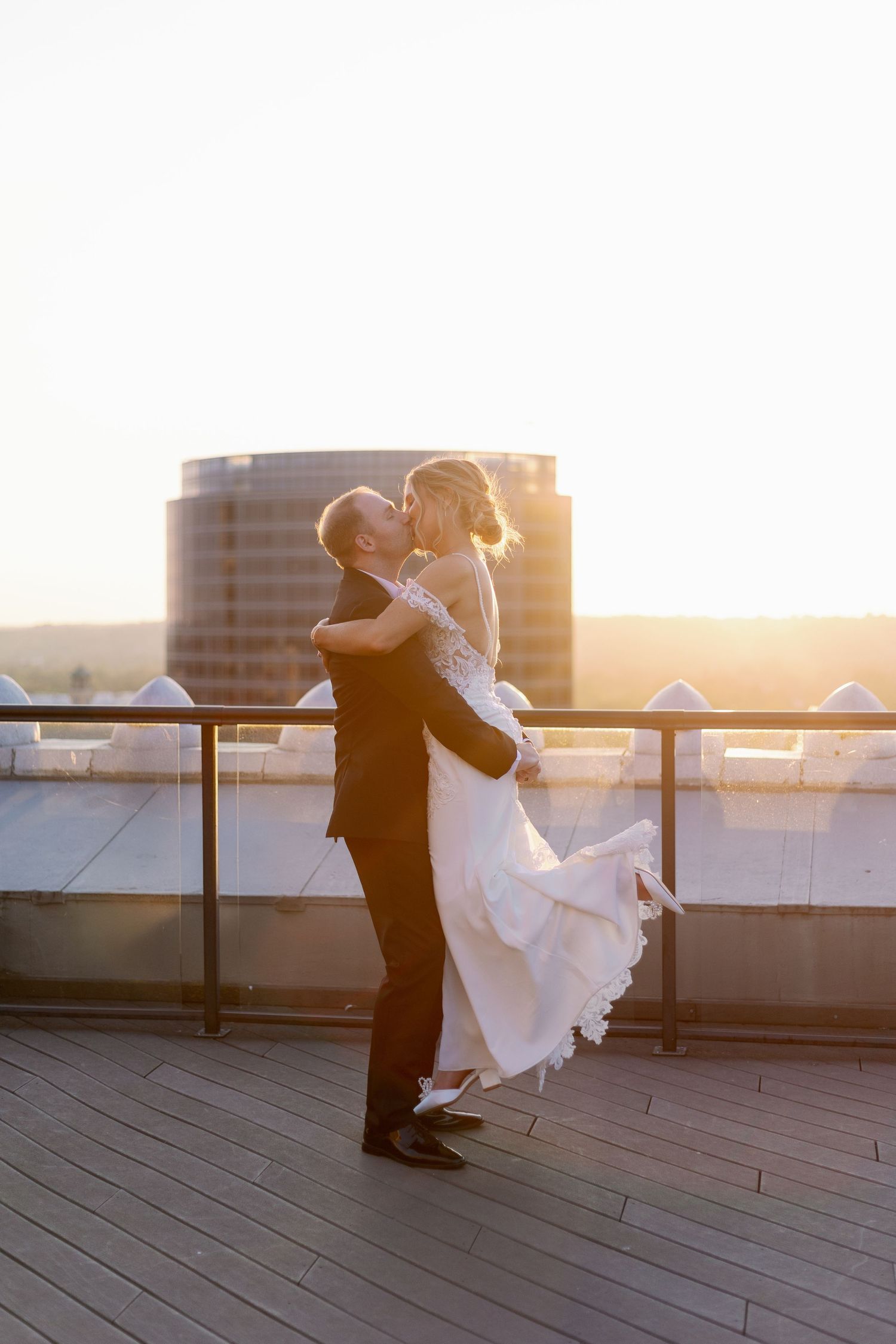 A couple shares a romantic sunset moment on a rooftop terrace during their wedding celebration at Ballroom at the McKay in Downtown GR.