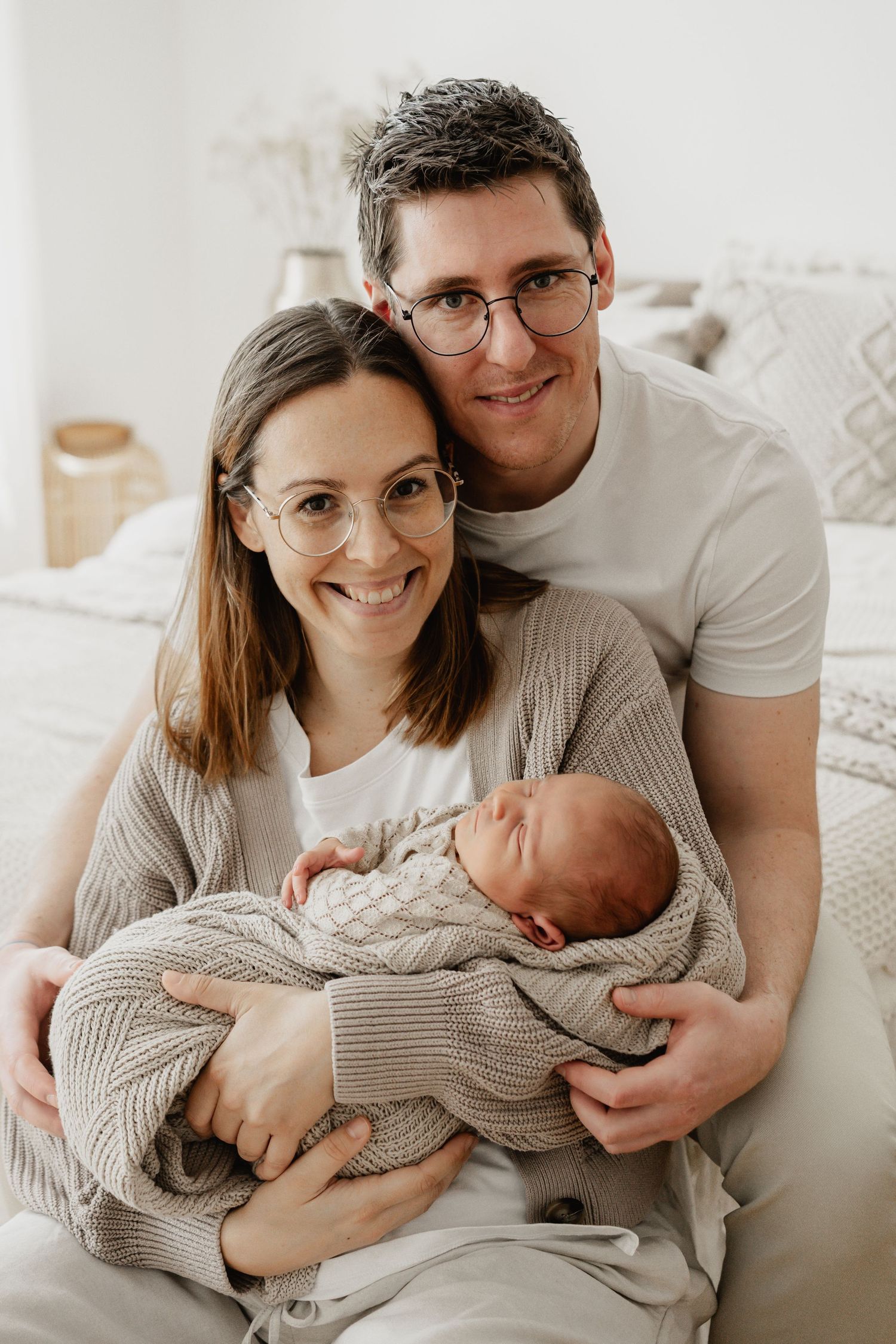 Newbornfotoshooting, junge Eltern beim Fotoshooting mit ihrem Neugeborenen im Arm, Stockerau, Wien, Tulln