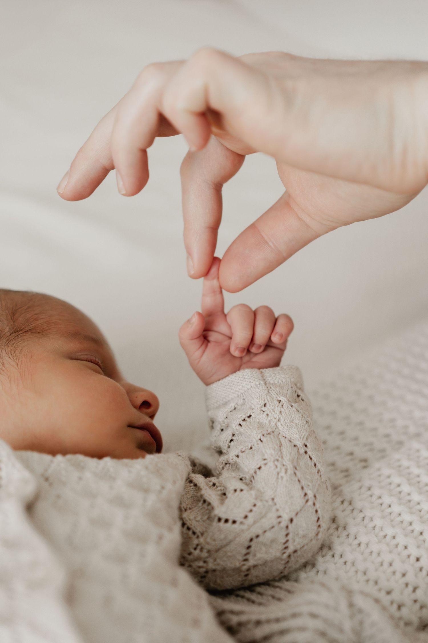 Detailfoto von der Hand eines Neugeborenen und der Hand der Mama, Babyfotograf Niederösterreich