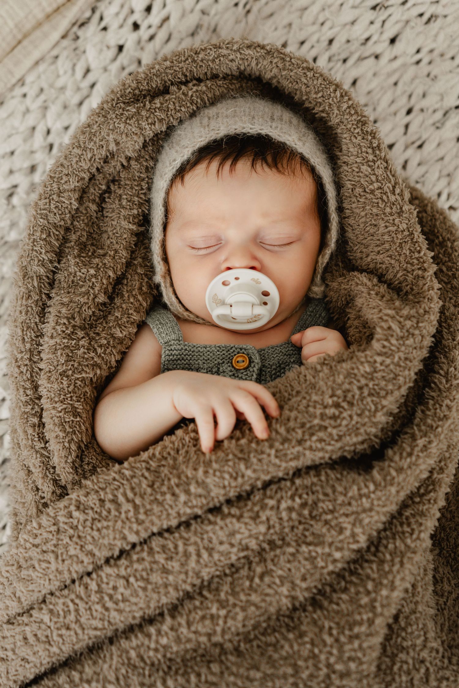 Newbornshooting Niederösterreich, Stockerau, Tulln, Korneuburg, Wien, Neugeborenes schläft in Decke beim Babyfotoshooting