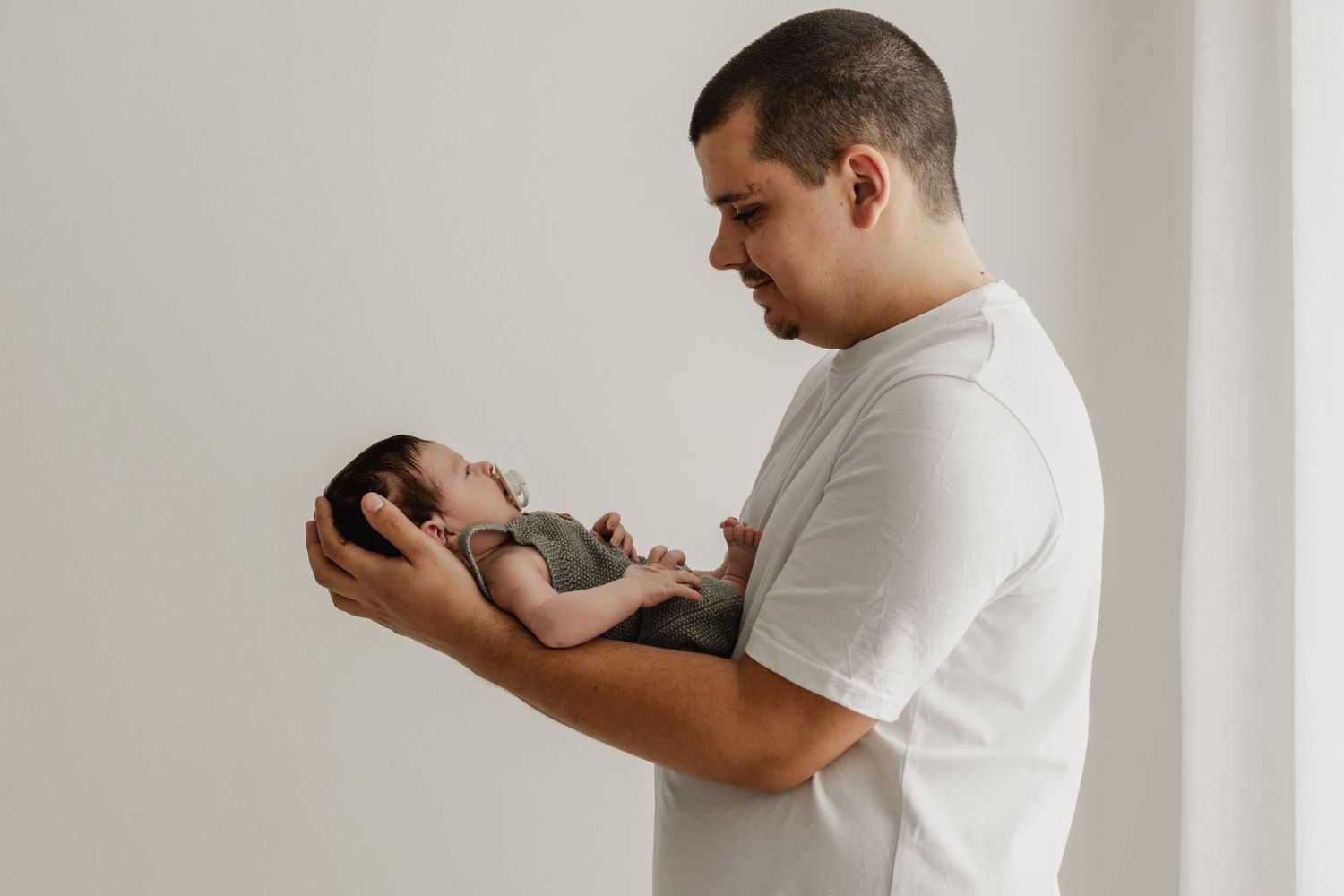 Babyshooting Wien Preise, Premiumfotoshooting Newbornshooting, Papa hält Baby im Arm, Fotoatelier Stockerau