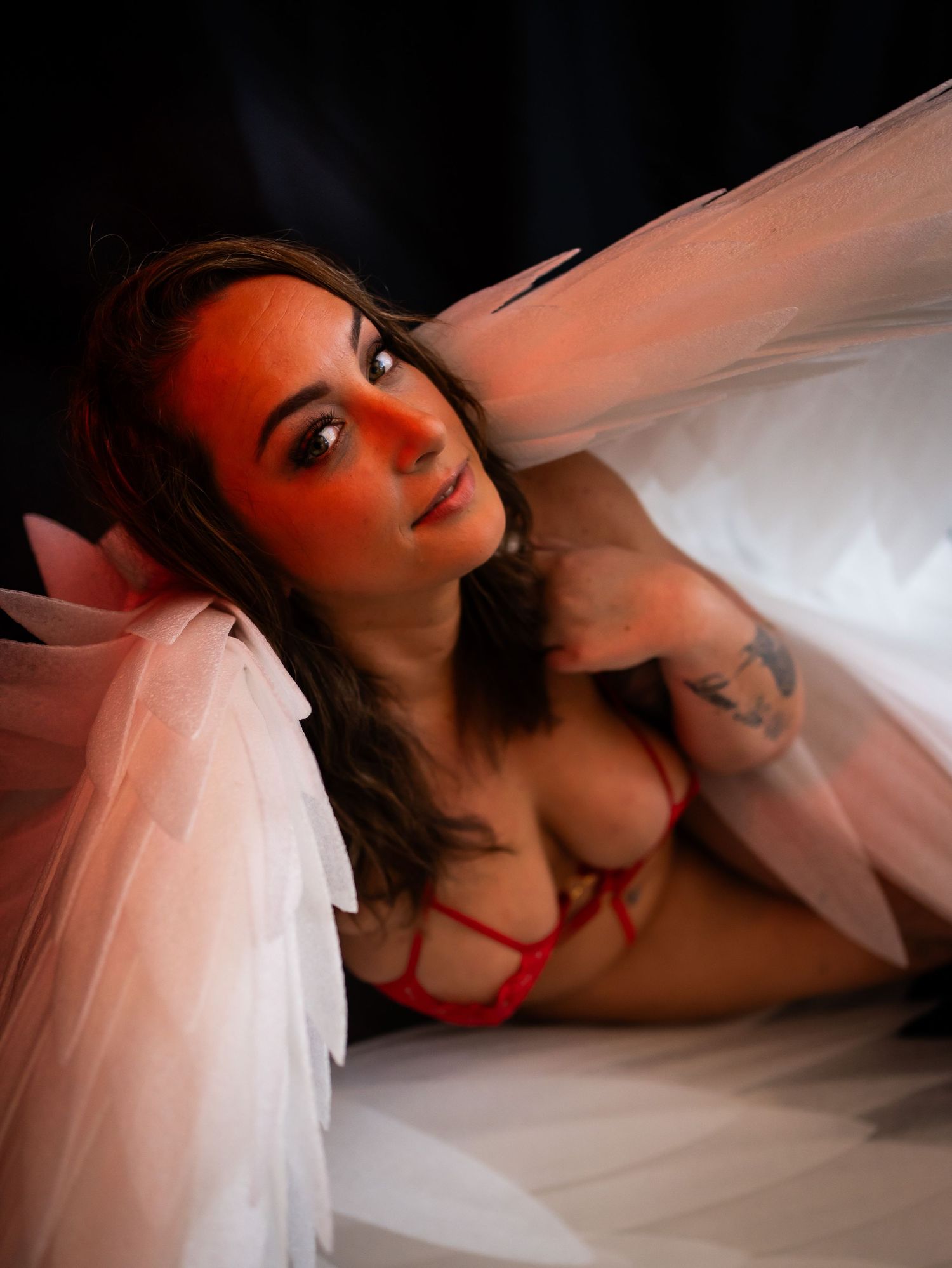 Dramatic boudoir scene with pink and blue lighting effects and atmospheric smoke.
