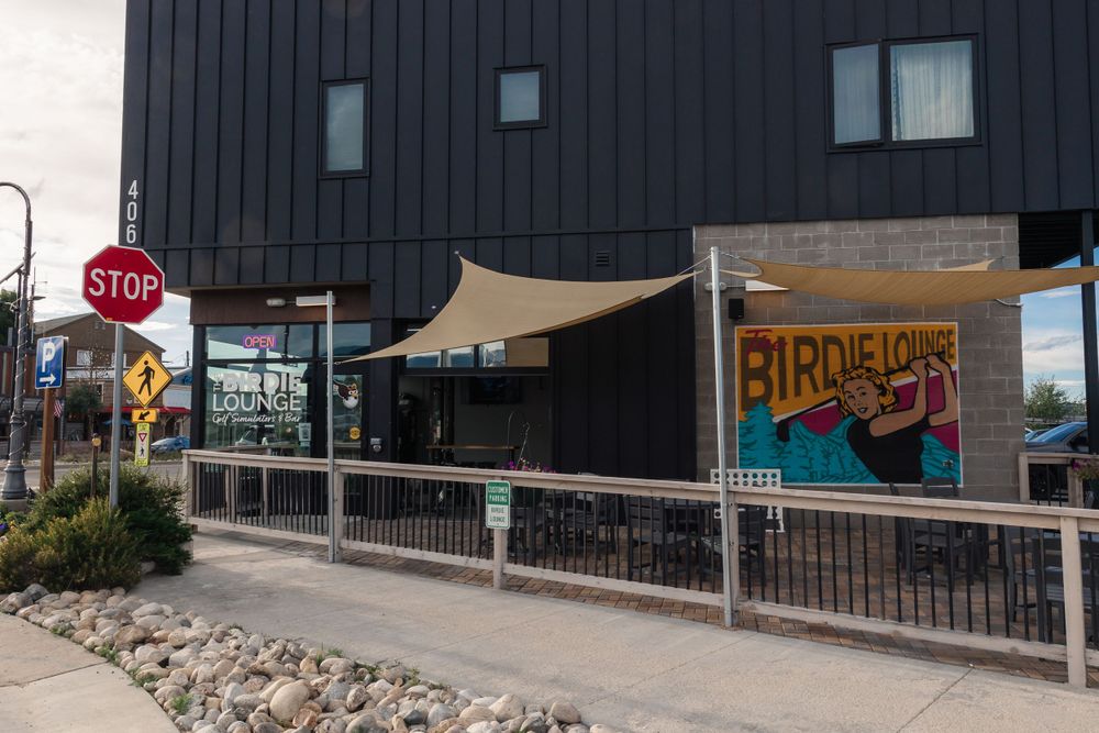 Exterior view of a black building with a Birdie Lou's sign and tan awning.