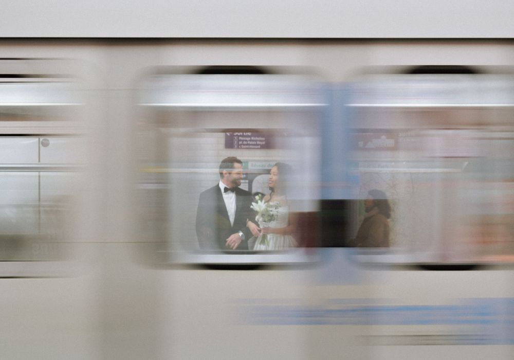 Motion-blurred photo showing a subway train window with a silhouetted figure visible through the glass.
