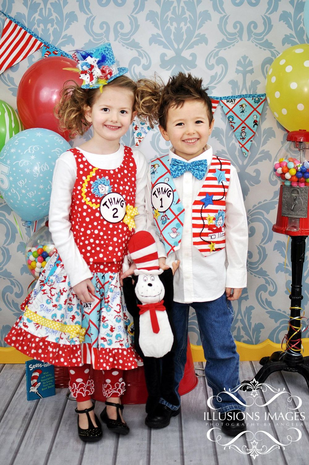 Festive Dr. Seuss themed party decor with balloons, gumballs, and children in red and blue coordinated outfits.