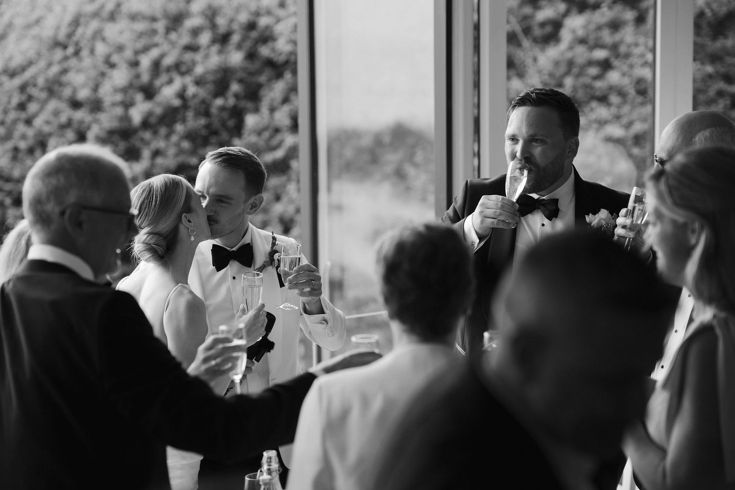 bride and groom kissing during speeches at Tunnels Beach wedding venue in north devon