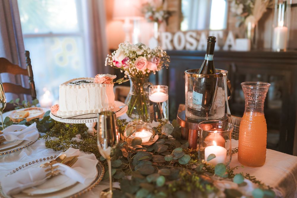 Elegant wedding reception table settings with pink floral centerpieces, candles and romantic lighting create an intimate atmosphere.