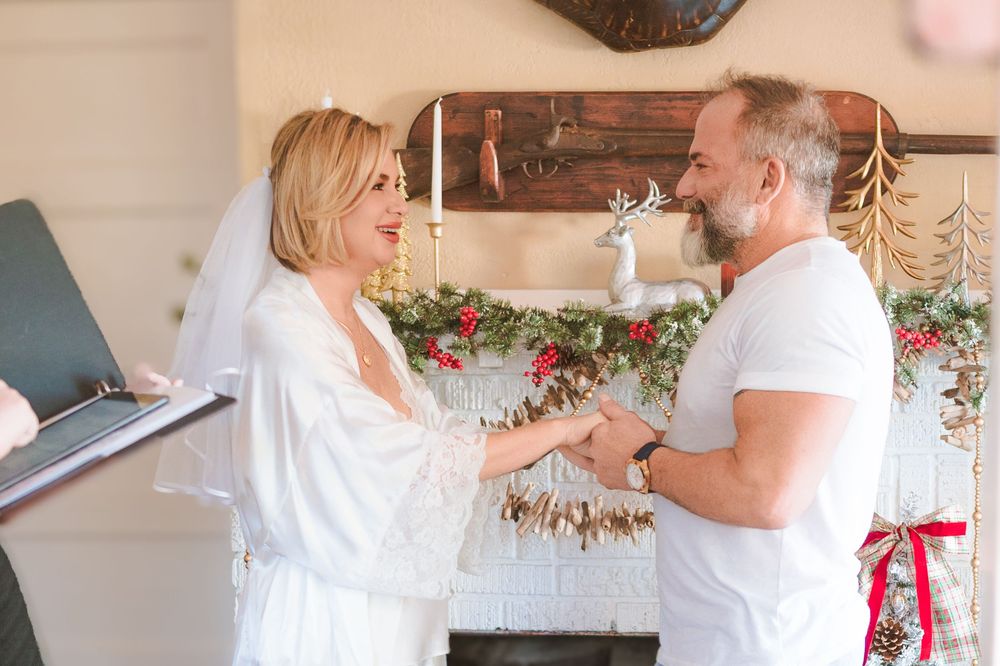 Wedding celebration scene with white decor and floral arrangements in a rustic indoor venue.