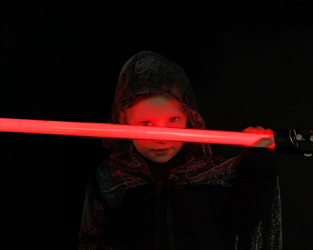 A dark scene with a glowing red light bar casting an eerie illumination across the frame.