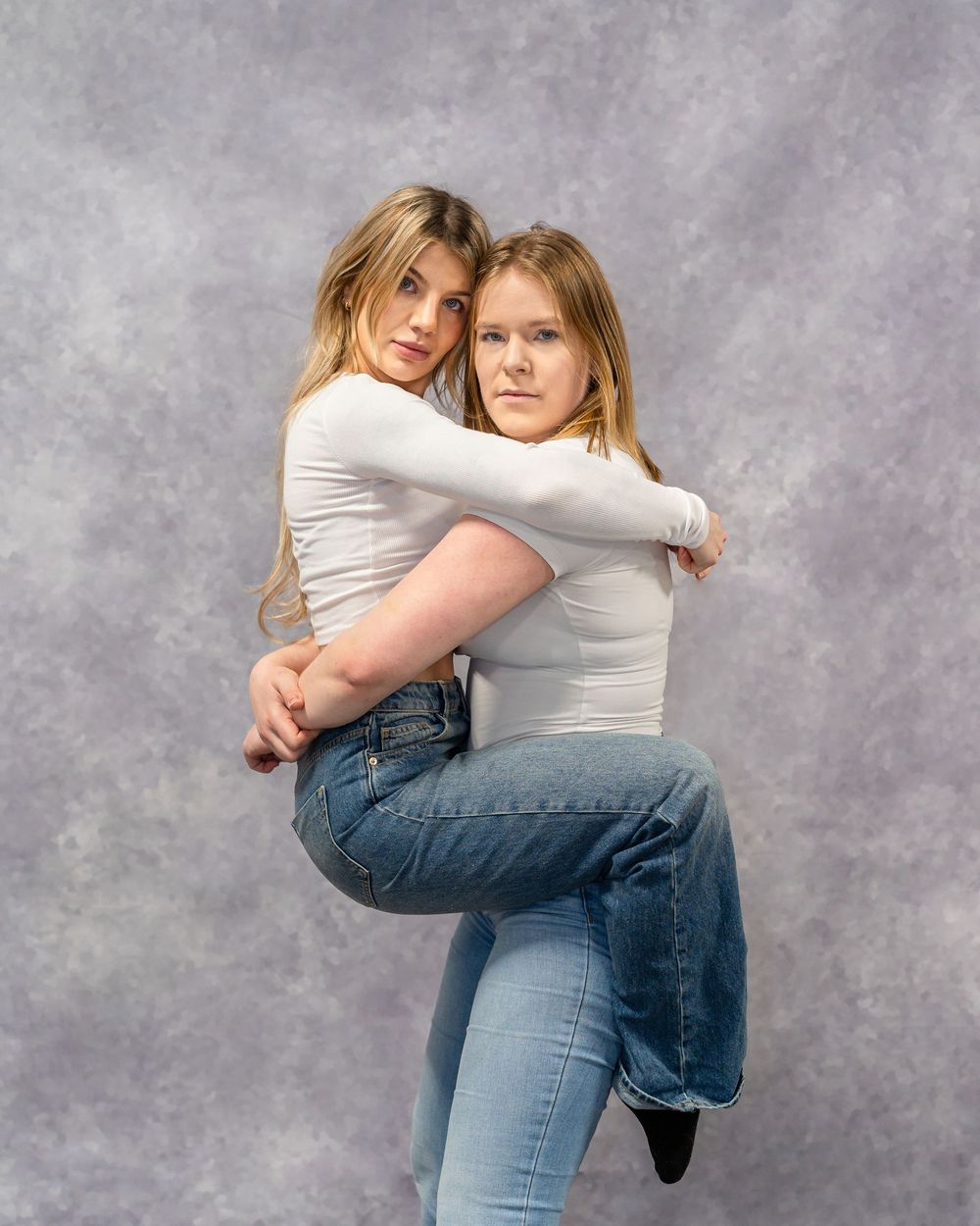 Dynamic paired pose showing connection between two dancers in casual attire.