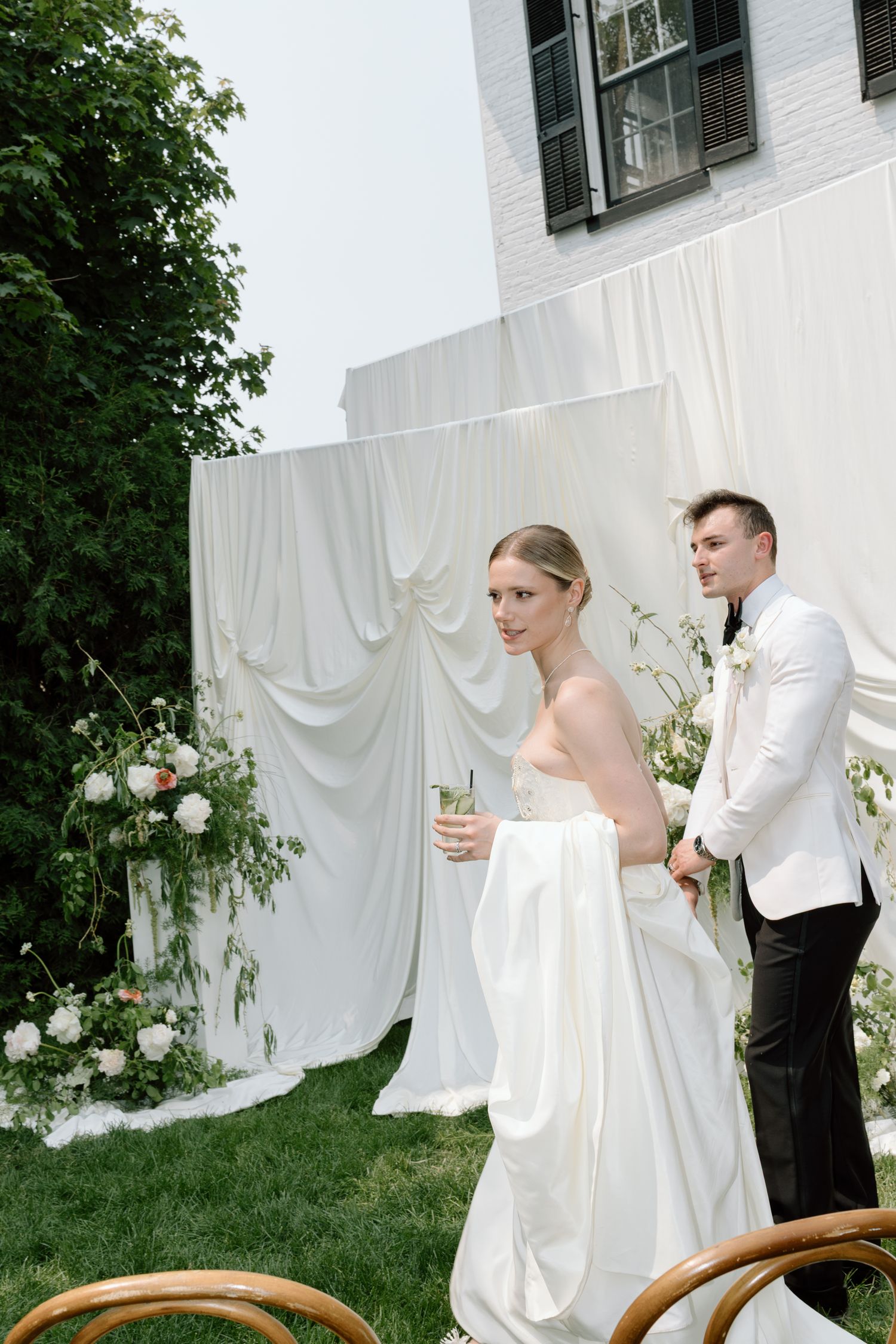 Black and white photo of newlyweds sharing intimate moment outside wedding tent.