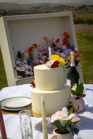 2 tier wedding cake with off white fondant and fresh spring flowers made by Crystal with Rose Hill Bakery set on sweetheart's table