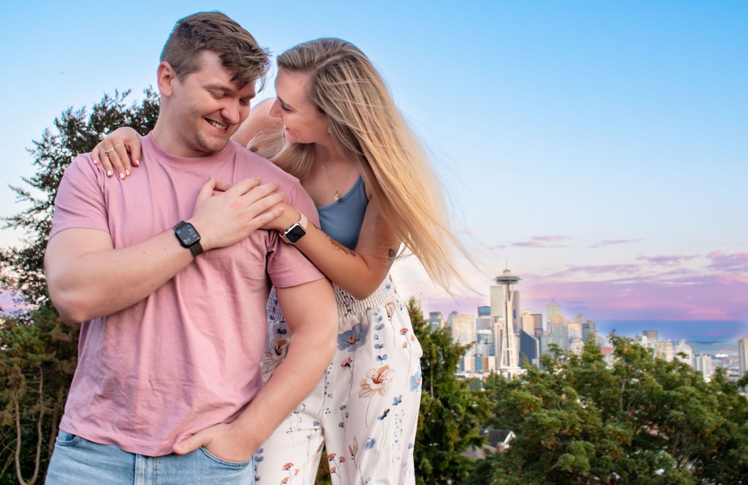 Playful couple embracing at golden hour with skyline views—romantic engagement or couples session in Seattle, WA.