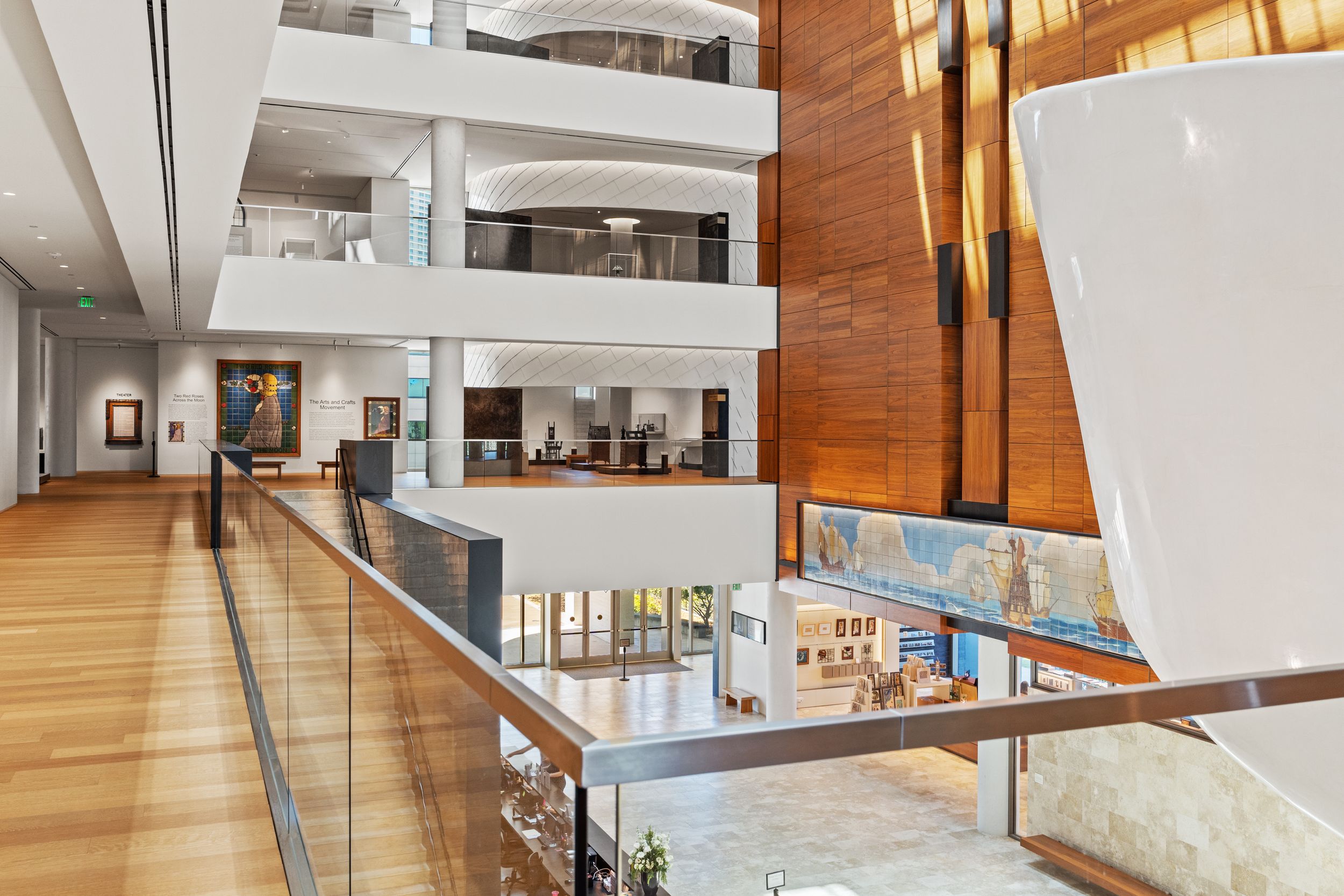 Contemporary gallery space with wooden walls and angular white architectural elements.