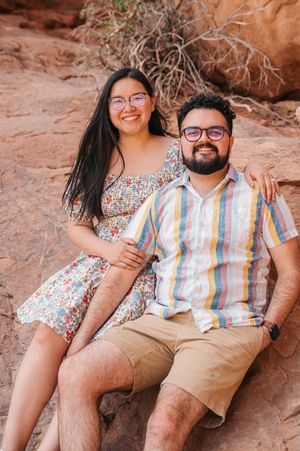 A female and male sitting on rocks at Arches National Park.