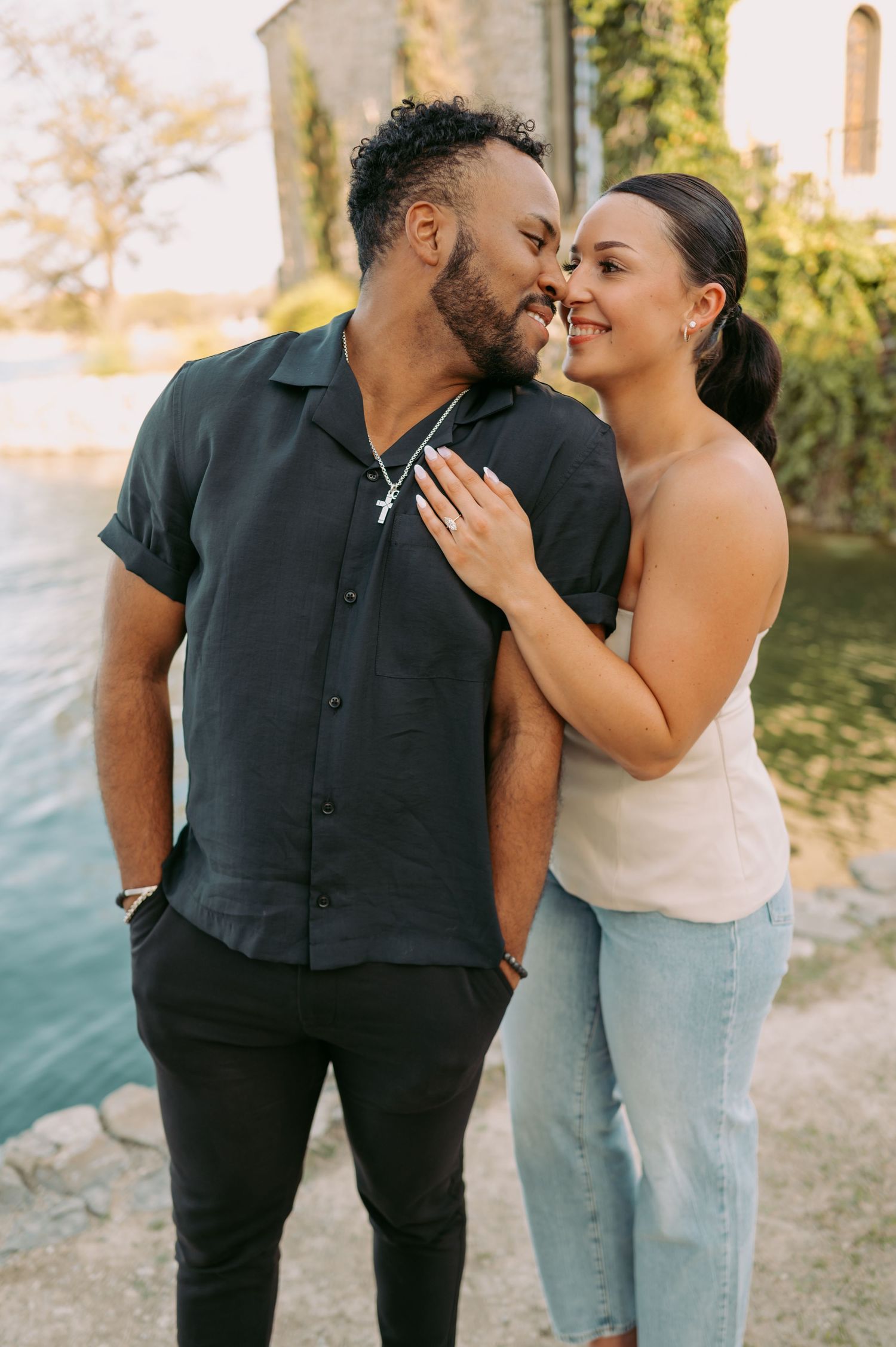 A tender engagement moment captured outdoors with a church in the background.