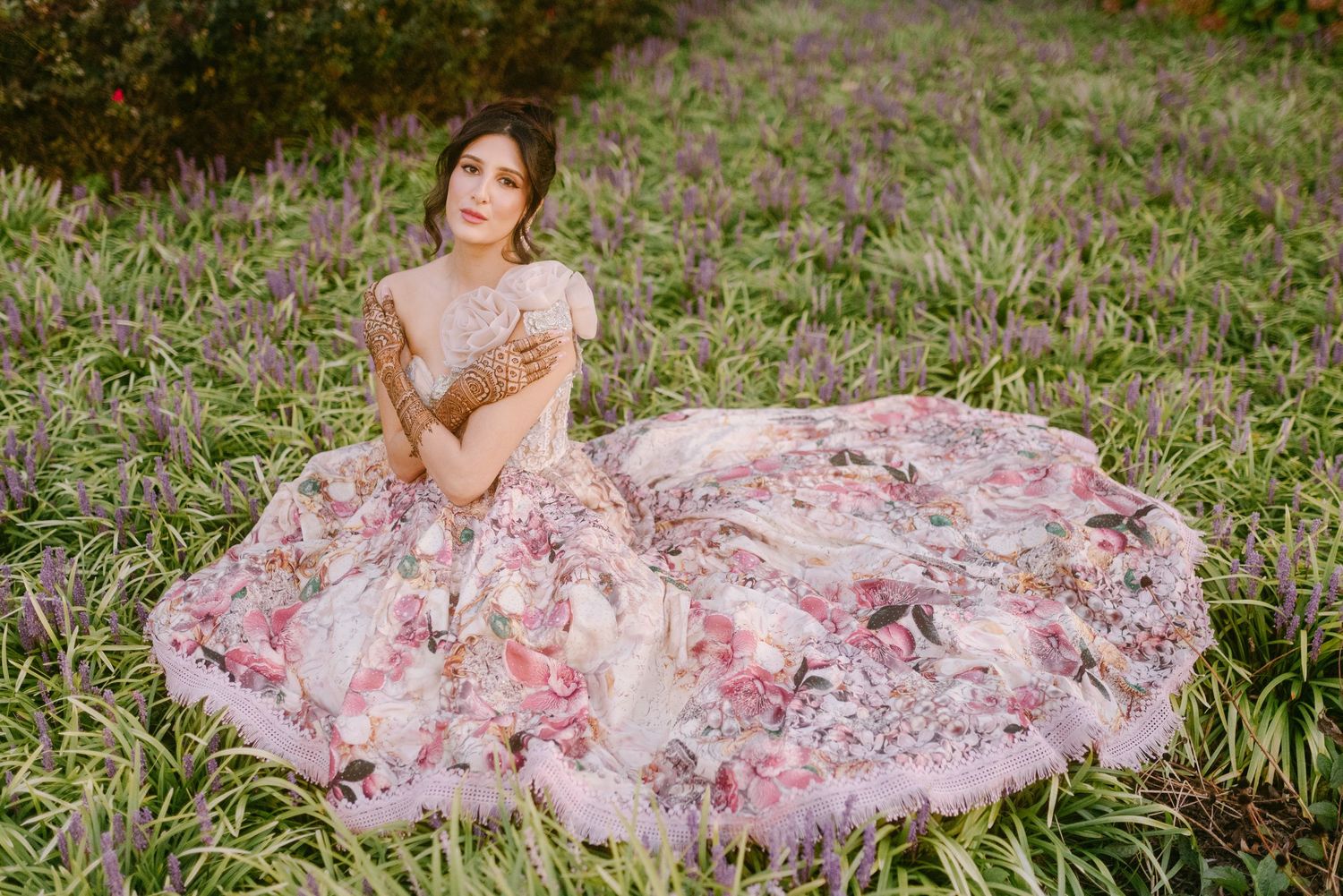 Floral pink and white dress spread out in a circular pattern on grass outdoors.