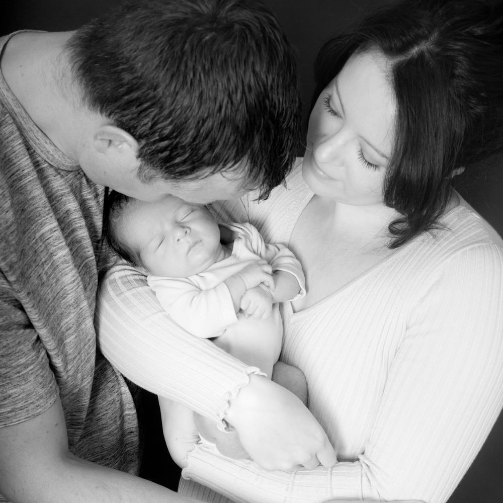 Mother cuddling her newborn baby wrapped in a soft blanket Newborn photography by Abigail's Studio, Buckinghamshire