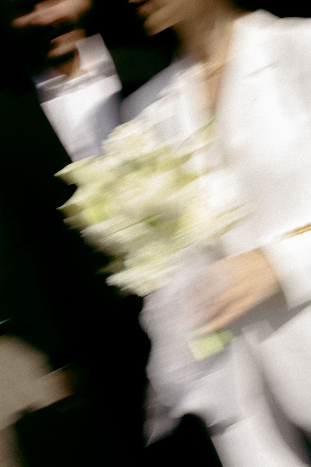 Motion blur capture of white wedding dress and bouquet creating artistic effect. Destination wedding in London, UK.