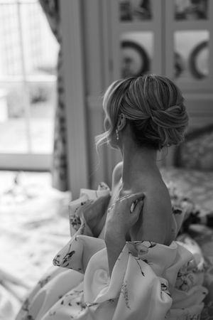 Artistic black and white photo showing intricate back detail of a floral wedding gown.