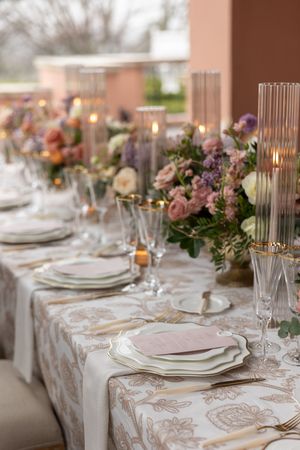 An elegant wedding reception table setting with floral centerpieces and crystal glassware.