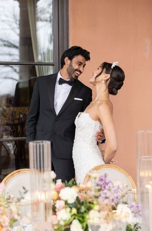 A romantic wedding moment captured with a decorated table setting and candlelight in the foreground.