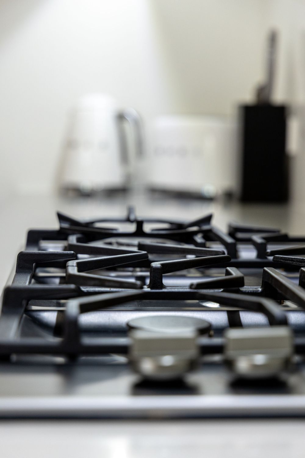Close-up view of a modern stainless steel gas stove burner with black grates.