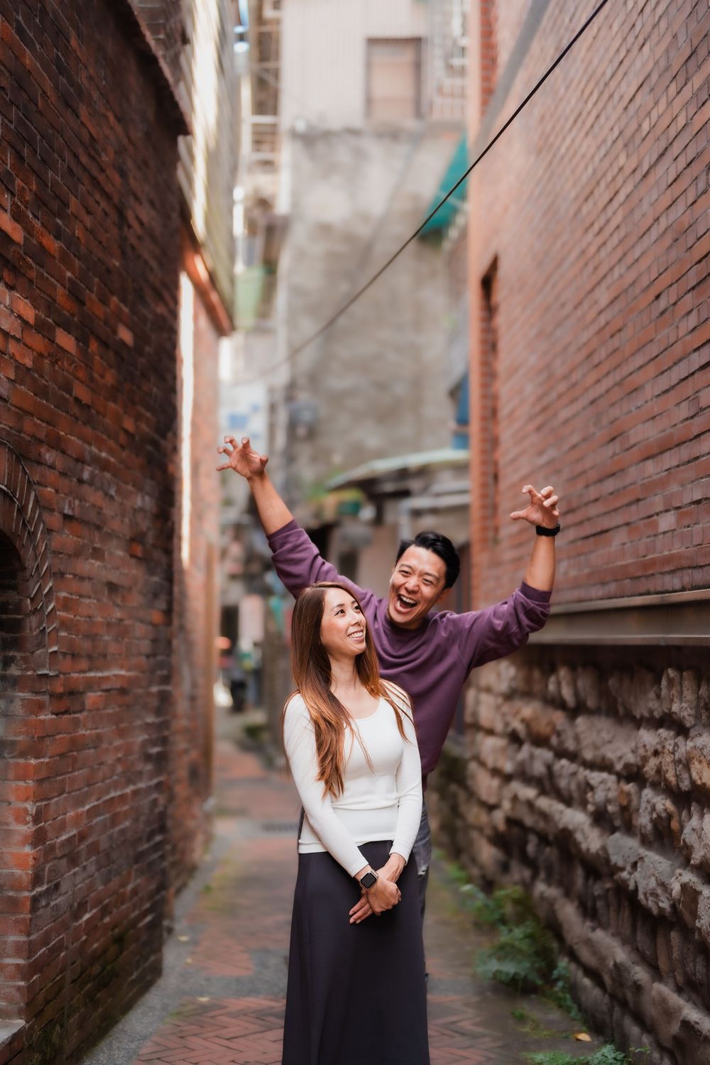 A couple having a playful moment in a narrow alleyway at Dihua Street in Dadaocheng, Datong District, Taipei.
