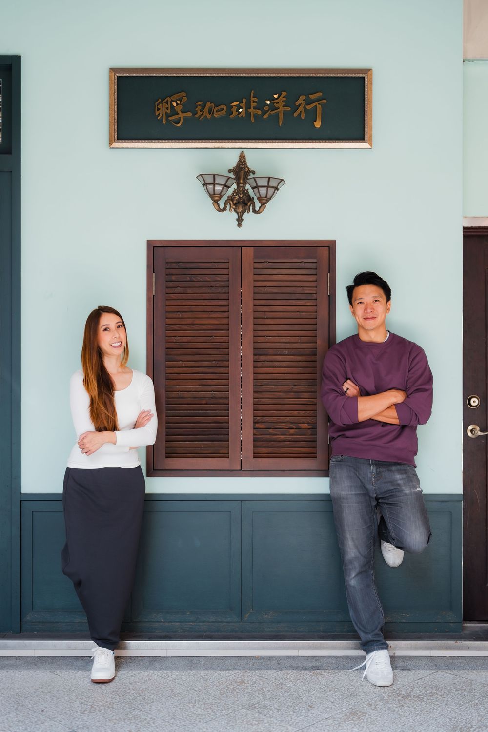 A couple stands against a wall at Dihua Street in Dadaocheng, Datong District, Taipei.