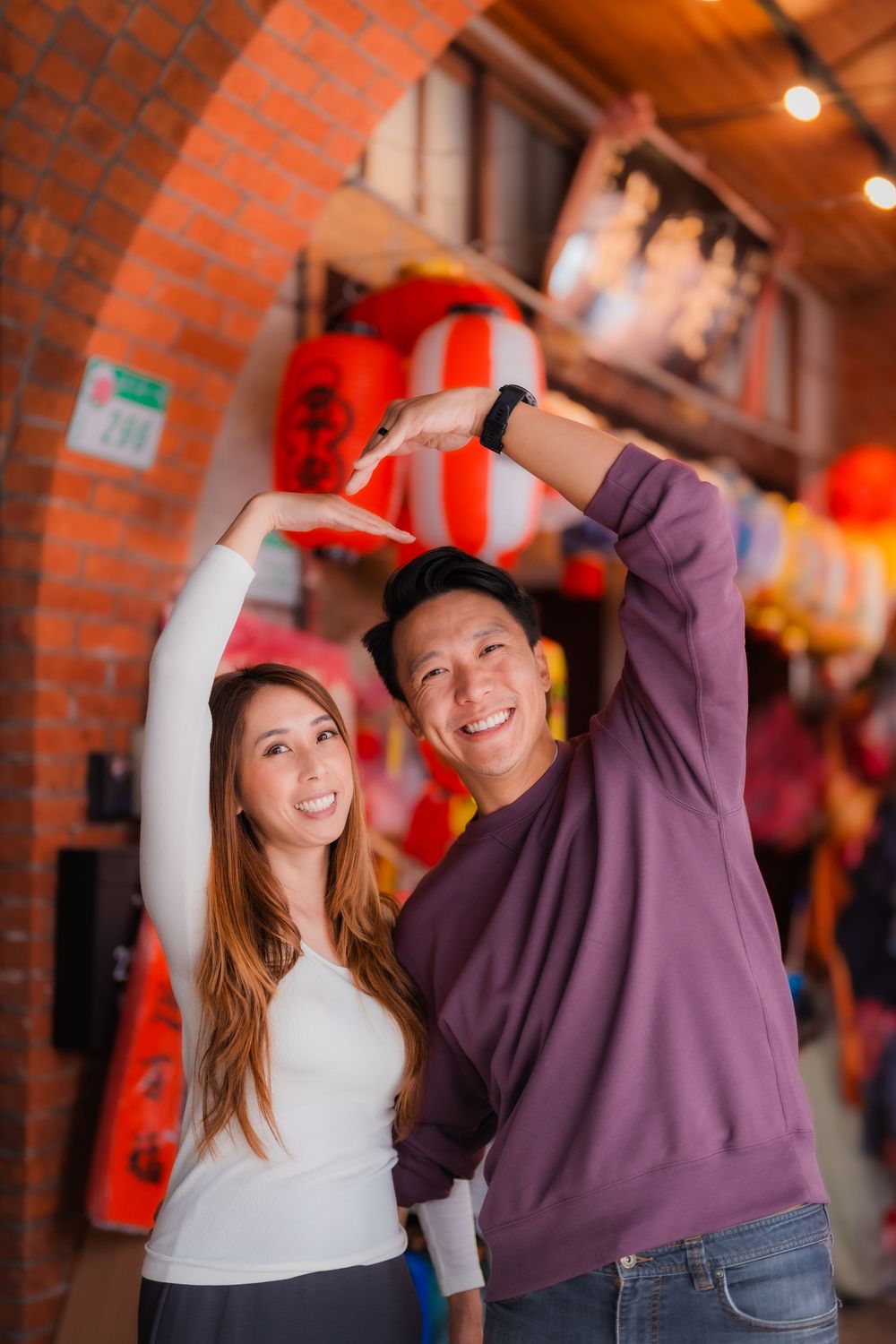 A couple poses with a heart sign at Dihua Street in Dadaocheng, Datong District, Taipei.