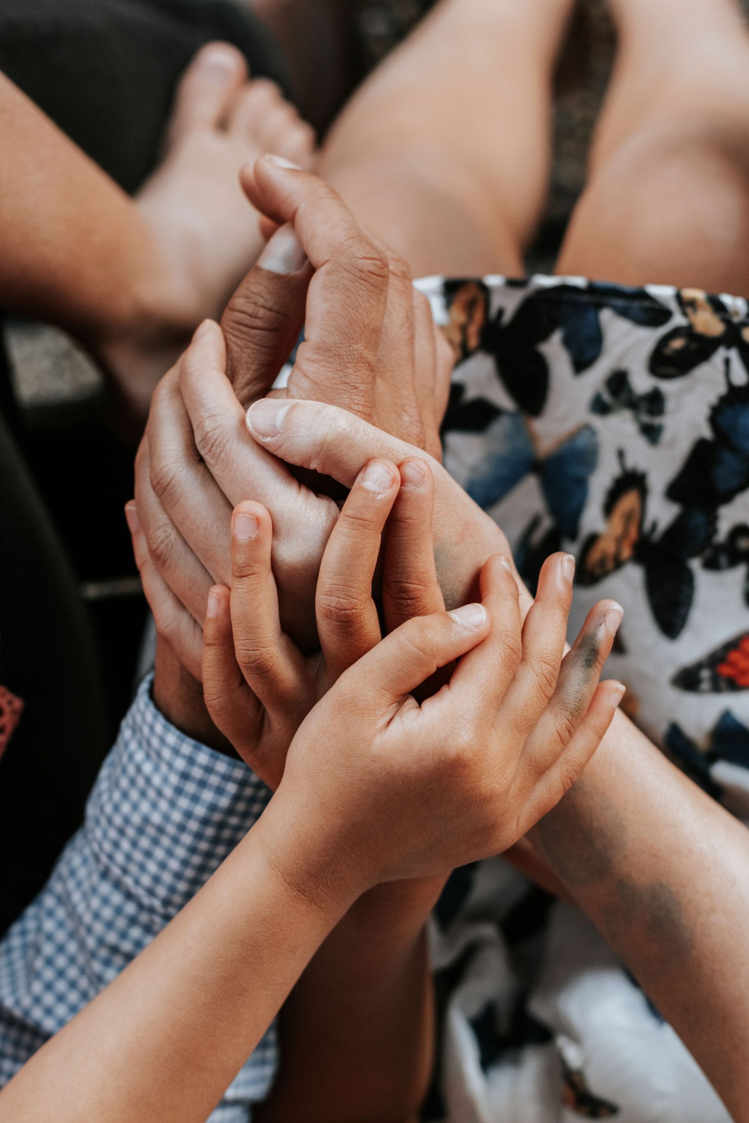 Multiple generations of hands held together, symbolizing family unity, support, and connection across ages.