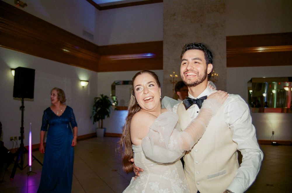 Bride and groom share a joyful dance at their wedding reception in an elegant venue.