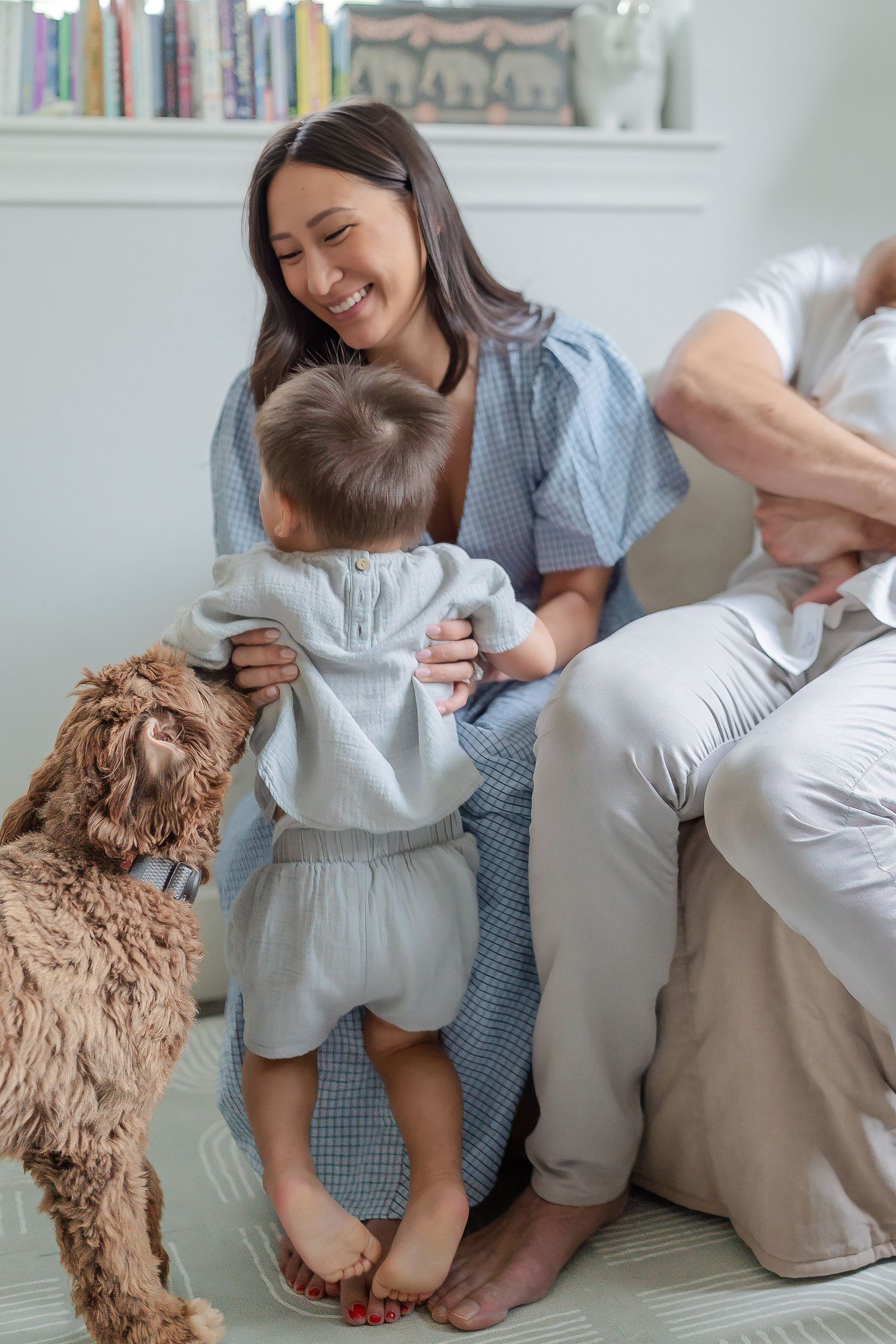 Mom wearing baby blue dress playing with toddler in nursery