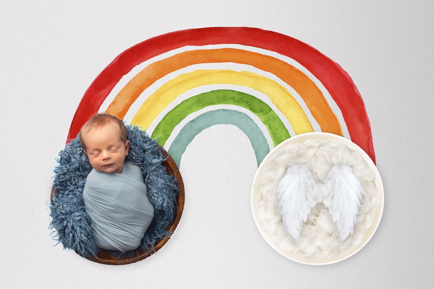 Newborn baby sleeping in wooden bowl with blue wrap beside angel wings on rainbow backdrop.