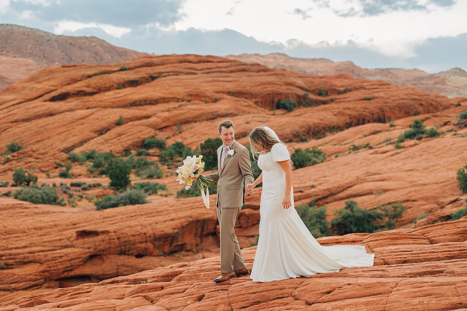 Bride and groom exchange vows among stunning red rock formations in a scenic desert wedding ceremony.