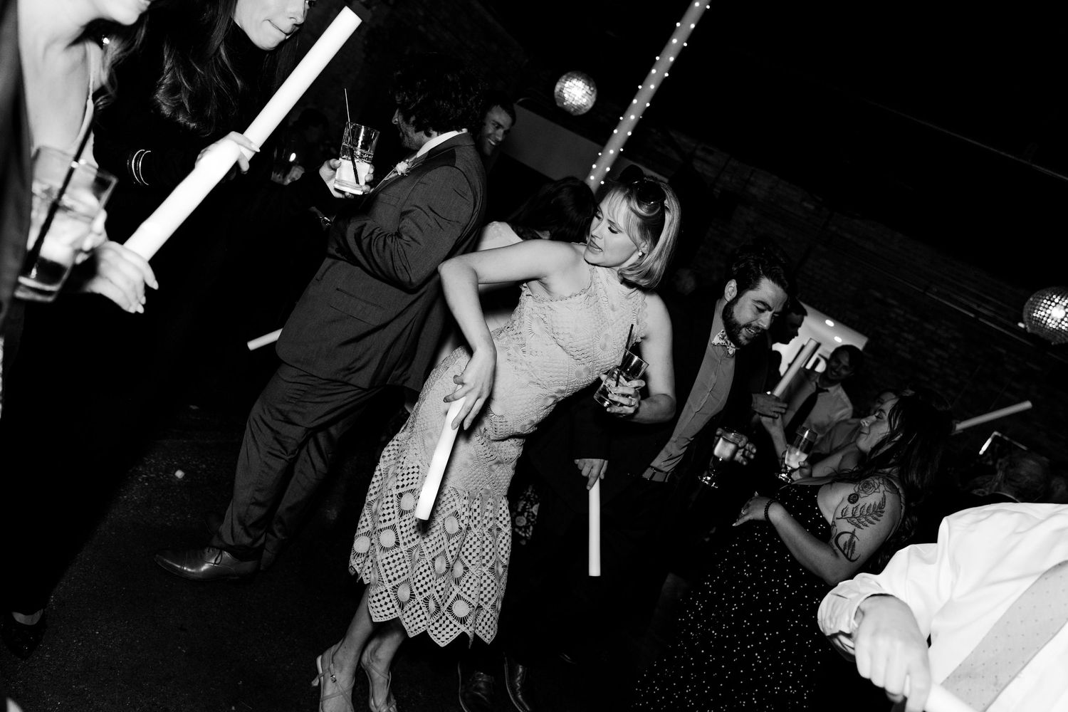 Black and white photo of people dancing at a lively nightclub party event.