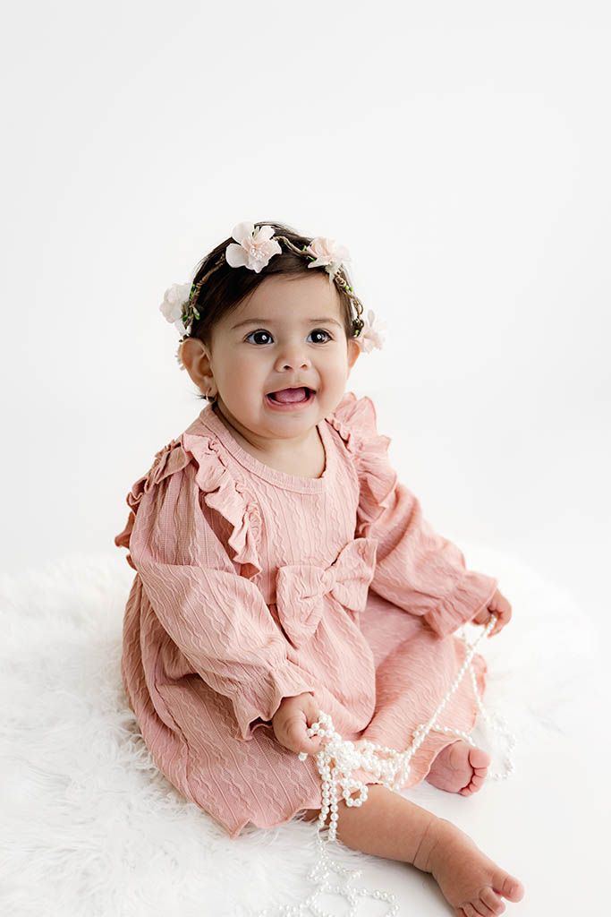 Menifee 1st birthday photography - Smiling baby girl in pink ruffle dress and floral crown.