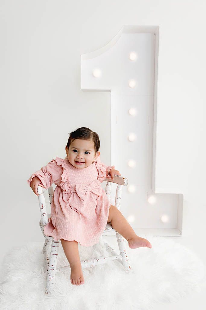 Menifee 1st birthday photographer photo of baby girl's first birthday sitting in front of 1 marquee number.