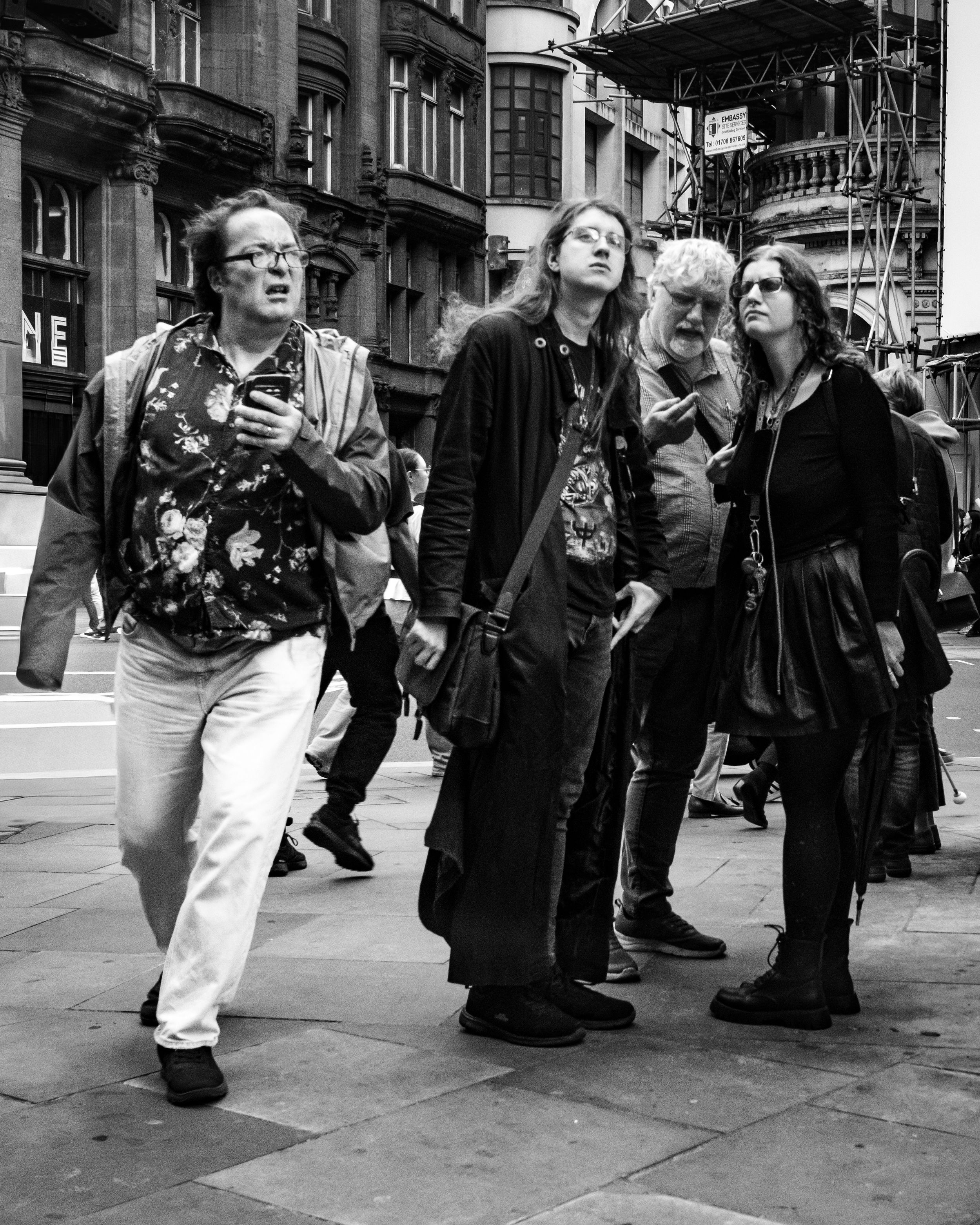 Black and white candid street photography of a group of people walking together