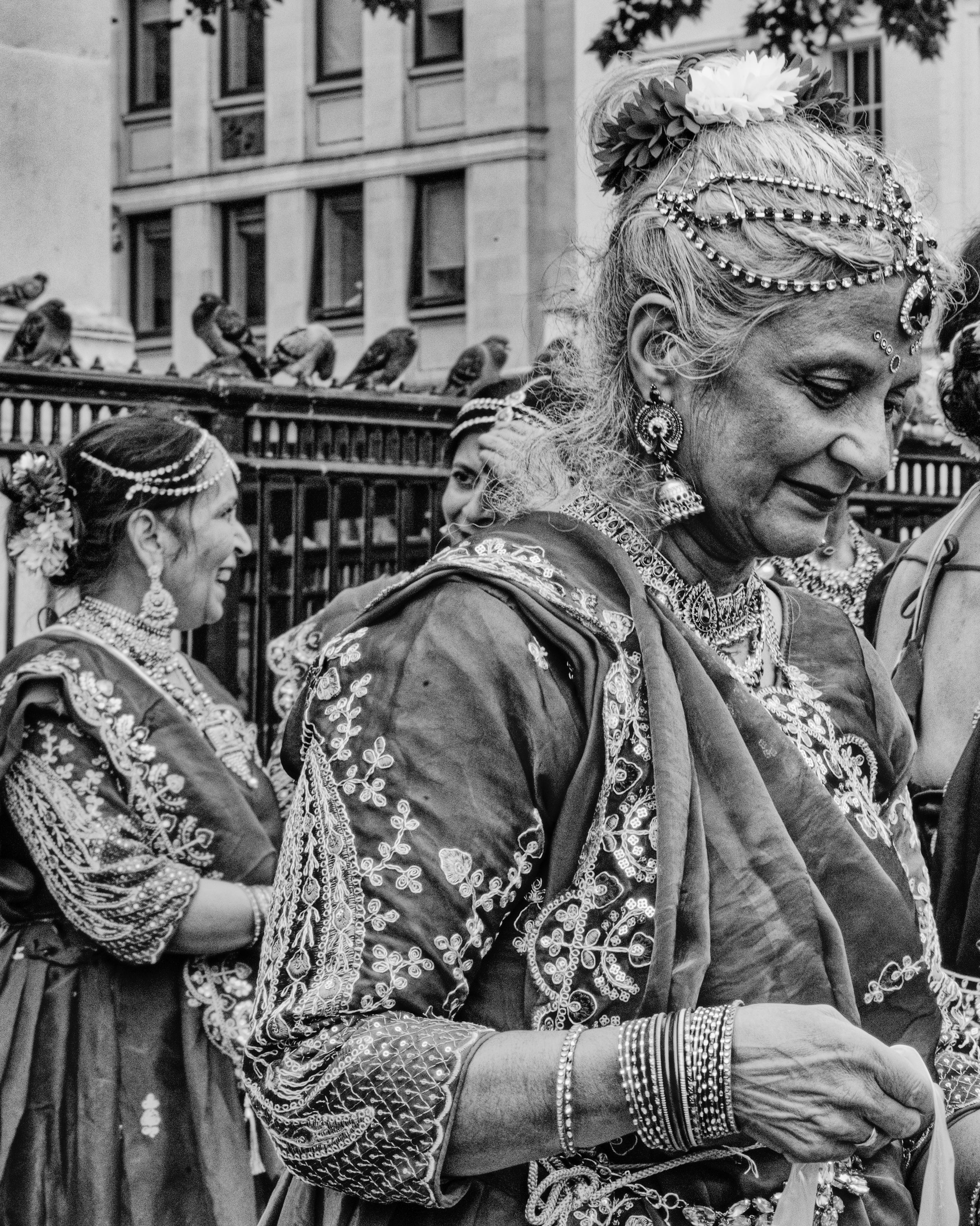 Black and white street photography of people in elaborate traditional costumes at a parade