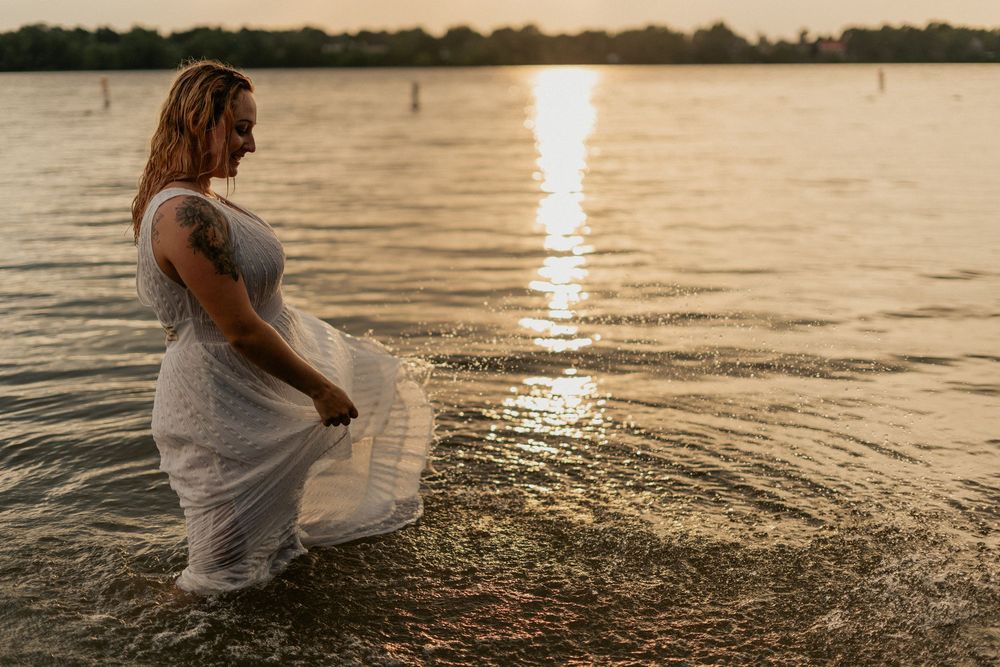Romantic sunset photoshoot at a lake with silhouettes and reflections creating dreamy water scenes.