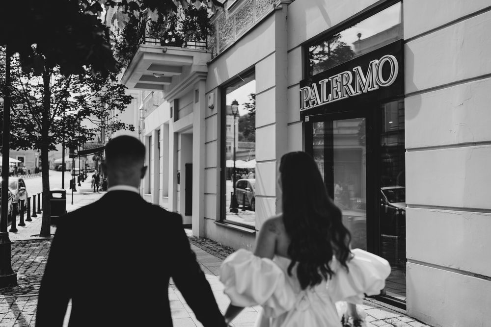 Couple walks together along urban street with historic buildings.
