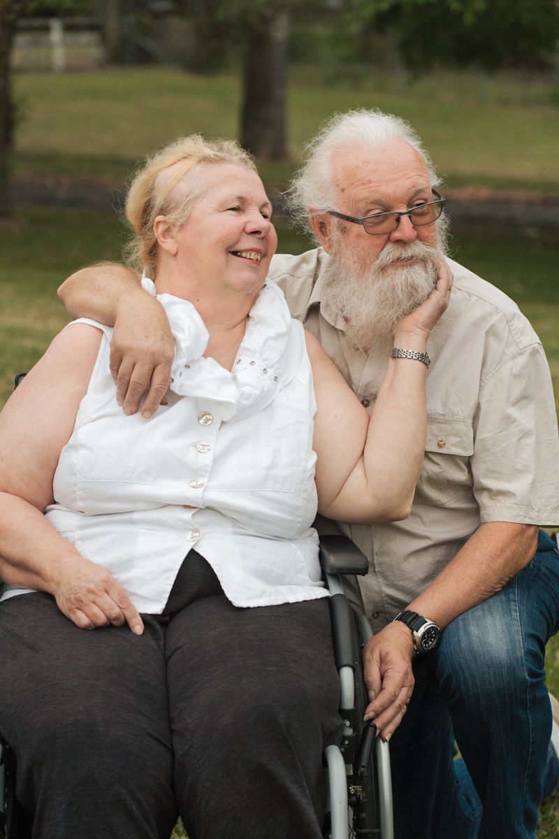 A couple shares a joyful moment together outdoors during a family photoshoot in the gables in sydney
