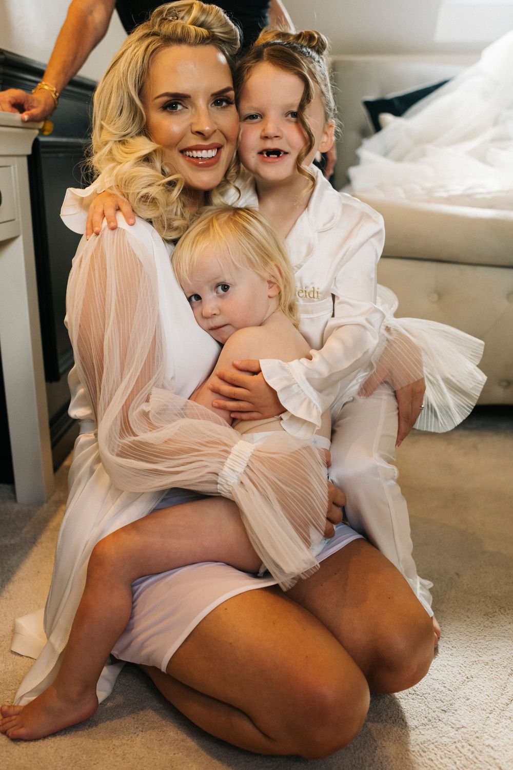 Intimate wedding preparation moments captured in soft white robes and delicate tulle.