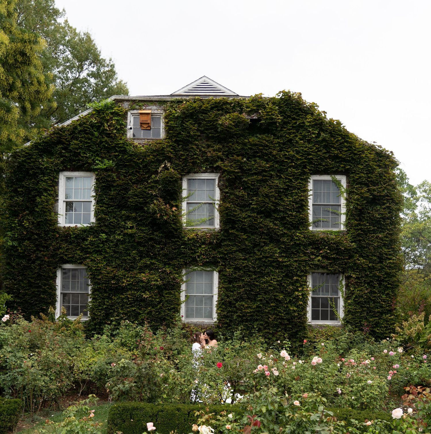 couple in front of leafy house