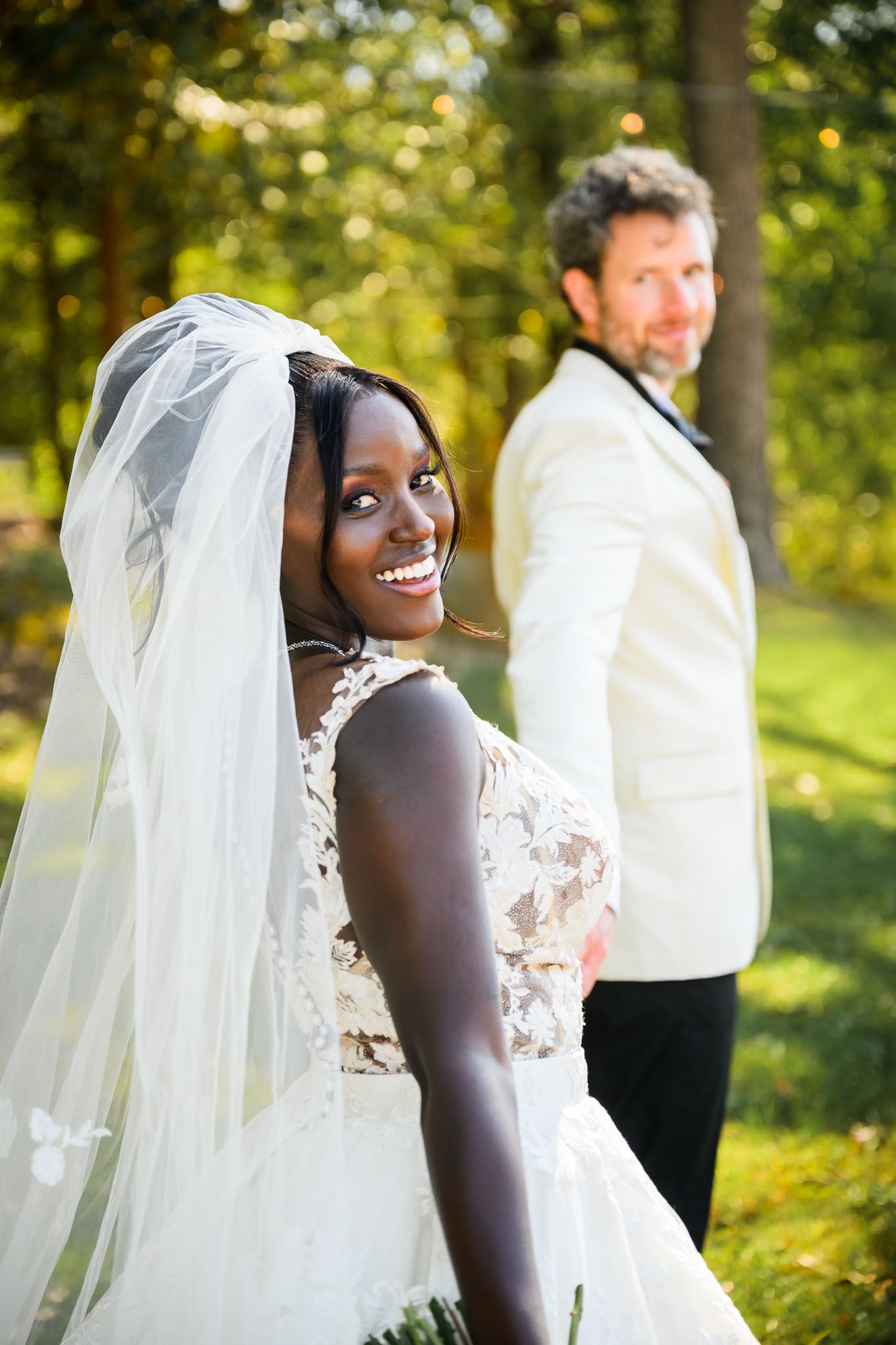 Wedding couple poses at church altar with crucifix and stained glass windows in background.