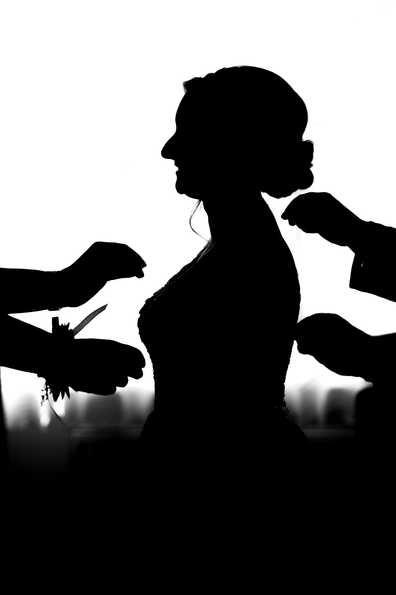 Artistic silhouette series of bride getting ready on wedding day.
