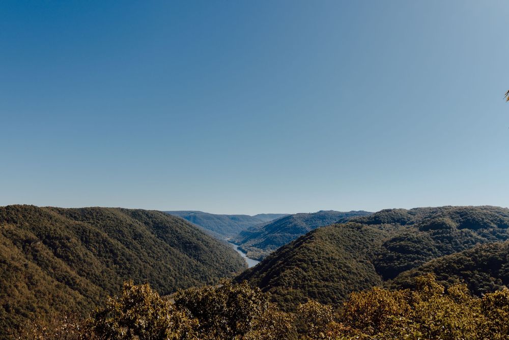 Sweeping panorama of mountain ranges under clear blue skies.