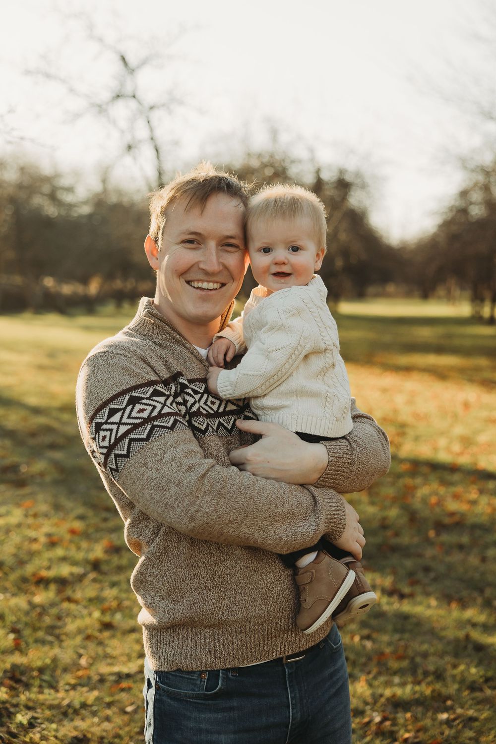 A heartwarming outdoor photo session at sunset in a grassy field during autumn.